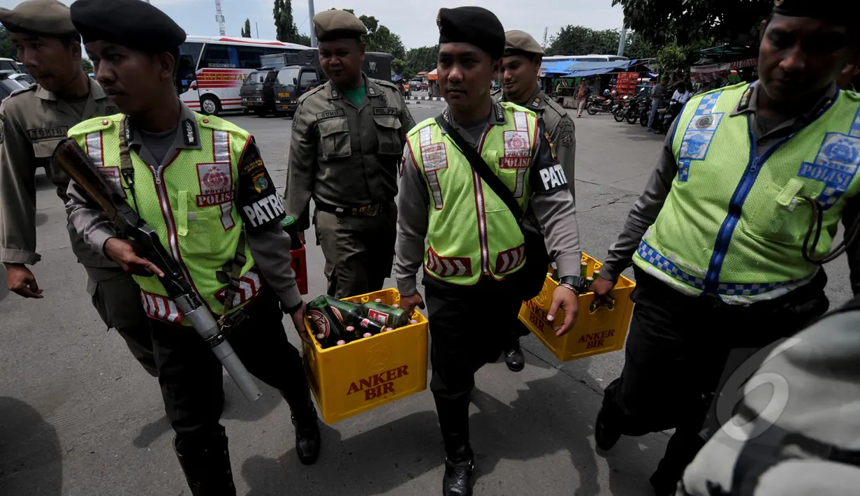 Petugas polisi saat mengamankan sejumlah minuman keras di kawasan terminal Pulogadung, Jakarta Kamis, (12/3/2015). Petugas berhasil menyita minuman keras, senjata tajam, dan belasan orang yang diduga preman di lokasi tersebut. (Liputan6.com/Johan Tallo)