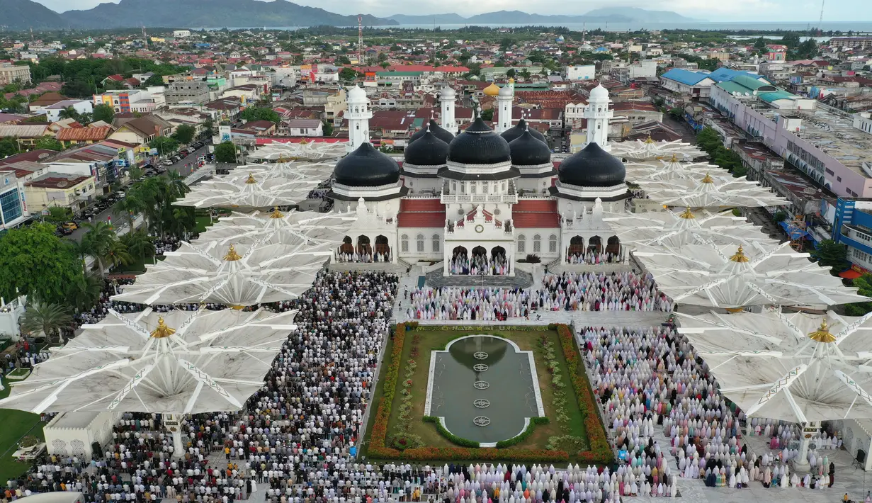Foto dari udara menunjukkan umat muslim melaksanakan salat Idul Fitri di Masjid Baiturrahman, Banda Aceh, Aceh, Indonesia, Minggu (24/5/2020). Idul Fitri tahun ini dirayakan umat muslim seluruh dunia di tengah pandemi virus corona COVID-19. (ADI GONDRONK/AFP)