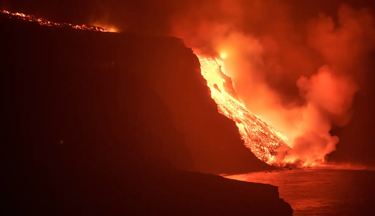 Lava dari gunung berapi mencapai laut di pulau Canary La Palma, Spanyol, Rabu (29/9/2021) dinihari. Lava merah panas dari gunung berapi Cumbre Vieja mencapai Samudra Atlantik, sembilan hari setelah mulai mengalir menuruni gunung. (AP Photo/Saul Santos)