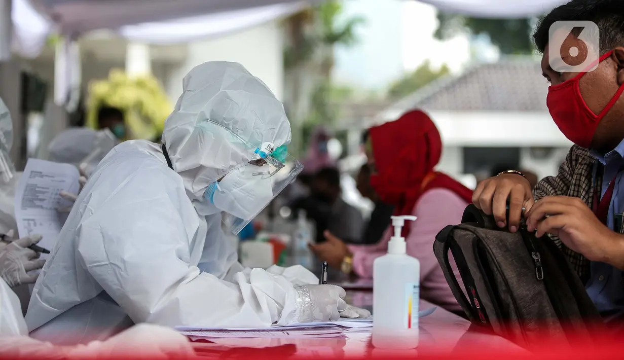 Petugas kesehatan mendata pegawai KPU dan Wartawan saat mengikuti swab test dan tes diagnostik cepat (rapid test) COVID-19 secara massal di Gedung KPU, Jakarta, Selasa (4/8/2020). (merdeka.com/Faizal Fanani)
