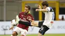 Gelandang AC Milan, Hakan Calhanoglu, berebut bola dengan gelandang Atalanta, Marten de Roon, pada laga lanjutan Serie A di Stadion San Siro, Sabtu (25/7/2020) dini hari WIB. AC Milan bermain imbang 1-1 atas Atalanta. (AP/Antonio Calanni)