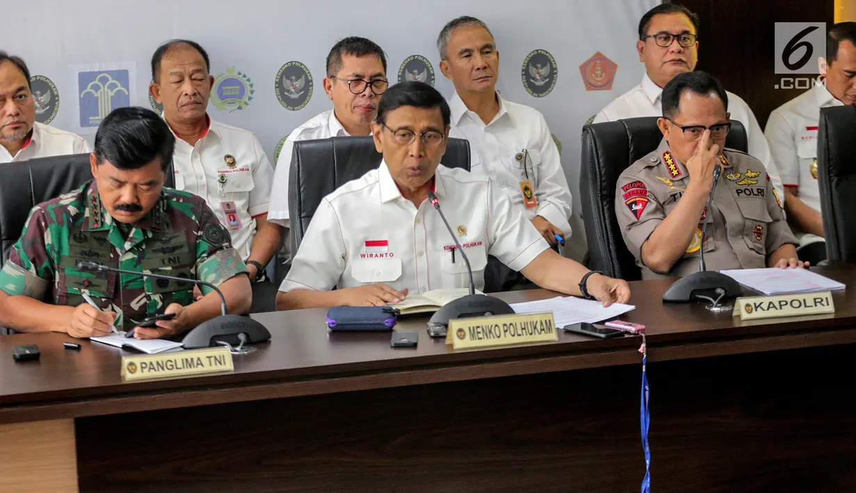 Menko Polhukam Wiranto (tengah) bersama Panglima TNI Marsekal Hadi Tjahjanto (kiri) dan Kapolri Tito Karnavian (kanan) memberi keterangan usai rapat koordinasi tertutup di Kantor Kemenko Polhukam, Jakarta, Selasa (24/9/2019). Rapat membahas isu-isu nasional terkini. (Liputan6.com/Faizal Fanani)