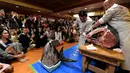 Kontestan Miss Internasional menyaksikan pemotongan ikan tuna sirip biru seberat 250 Kg yang akan di buat menjadi Sushi di Tokyo, Jepang (12/11). Para kontestan ini mengunjungi Jepang untuk mengikuti Miss Internasional. (AFP Photo/Toshifumi Kitamura)