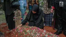 Istri mendiang George Mustafa Taka, Desty Amalia berada di dekat makam suaminya di Komplek Pemakaman Kempo, Jatiwaringin, Pondok Gede, Jakarta, Jumat (2/10). George Mustafa Taka meninggal akibat serangan jantung. (Liputan6.com/Faizal Fanani)