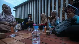 Menunggu waktu berbuka puasa di Masjid Istiqlal, sejumlah orang sedang membaca Al Quran. (Foto: Istimewa)