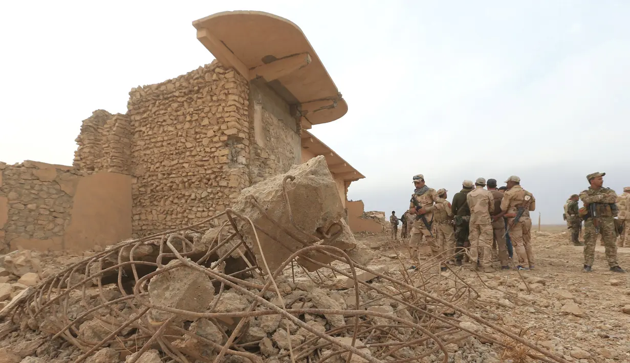 Anggota militer Irak berjalan di antara reruntuhan bangunan di situs kuno Nimrud. selatan Mosul, Irak, (16/11). Situs kuno yang berdiri kurang lebih 3.000 tahun lalu itu kini hancur oleh militan ISIS. (REUTERS/Ari Jalal)