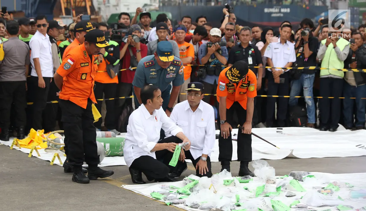 Presiden RI, Joko Widodo (tengah) melihat barang yang diduga milik penumpang pesawat Lion Air JT 610 di Pelabuhan JICT 2, Jakarta, Selasa (30/10). Sejumlah barang ditemukan petugas gabungan dalam operasi pencarian. (Liputan6.com/Helmi Fithriansyah)