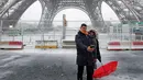 Pasangan berselfie di bawah Menara Eiffel di Paris, Prancis, (6/2). Badan cuaca nasional Prancis Meteo France mengatakan sekitar setengah negara di eropa siaga atas bahaya tingkat salju dan es yang berbahaya. (AP Photo / Francois Mori)