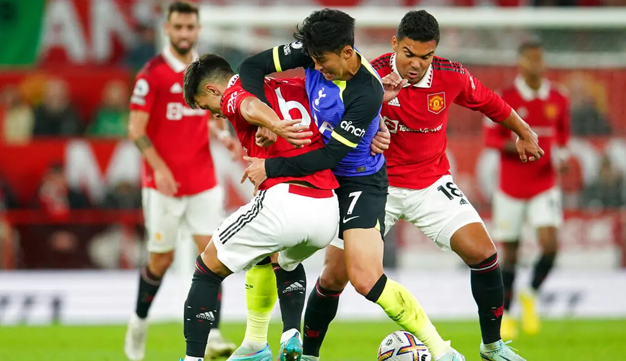 Pemain Tottenham Hotspur Son Heung-min (tengah) berebut bola dengan pemain Manchester United Lisandro Martinez (kiri) dan Casemiro (kanan) pada pertandingan sepak bola Liga Inggris di Old Trafford, Manchester, Inggris, 19 Oktober 2022. Manchester United mengalahkan Tottenham Hotspur dengan skor 2-0. (AP Photo/Dave Thompson)