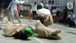 Peserta terjatuh saat beradu cepat dalam lomba balap karung helm di Kelurahan Benda Baru, Pamulang, Tangerang Selatan, Senin (17/8/2020). Lomba balap karung helm tersebut diselenggarakan untuk memeriahkan peringatan HUT ke-75 Kemerdekaan RI. (merdeka.com/Dwi Narwoko)