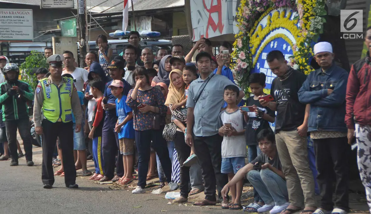Warga sekitar Puri Cikeas bersiap menyambut iring-iringan kepergian jenazah Ani Yudhoyono menuju TMP Kalibata, Bogor, Jawa Barat, Minggu (2/6/2019). Ani Yudhoyono dimakamkan di samping pusara istri presiden ke-3 RI BJ Habibie, Ainun Habibie. (Liputan6.com/Immanuel Antonius)