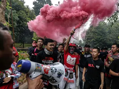 Suporter Timnas Indonesia menyalakan flare di sekitar Stadion Gelora Bung Karno (GBK), Senayan, Jakarta, Minggu (14/1). Timnas Indonesia vs Islandia akan berlaga malam nanti. (Liputan6/Faizal Fanani)