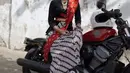 Dengan sneakers dan motor yang sama, Erika Carlina tampil beda sebagai Kartini. Ia mengenakan kebaya kutubaru hitam dengan kain Batik parang sebagai bawahan dan selendang bahu merah [@eri.carl]