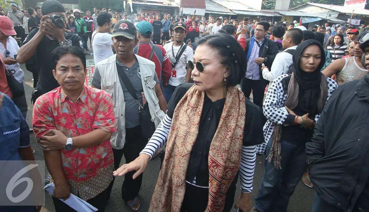 Ratna Sarumpaet menggunakan kaca mata hitam saat penertiban pemukiman penduduk di kawasan Rawajati, Jakarta, Kamis (1/9). Keberadaan Ratna di lokasi tersebut guna membantu mediasi warga yang rumahnya dieksekusi petugas. (Liputan6.com/Immanuel Antonius)
