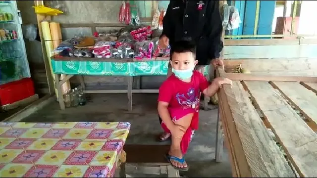 Salah seorang bocah di wilayah Desa Morosi, memakai masker di lokasi yang banyak dilalui TKA asal China,Minggu (2/2/2020).(Liputan6.com/Ahmad Akbar Fua)