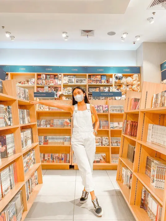 Dengan jumpsuit dan masker serba putih, Ayya tampil santai dan tetap modis. Gadis asal Malang ini pun nampak percaya diri berpose di antara rak buku. (Liputan6.com/IG/ayyarenita93).