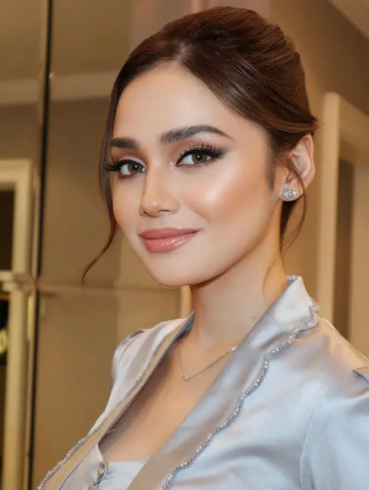Riasan mata dibuat lebih menonjol dengan eyeshadow nuansa coklat dipadu shimmer putih, fake eyelashes, wing eyeliner, dan sleek eyebrow yang on-point. [Foto: IG/syifahadju].