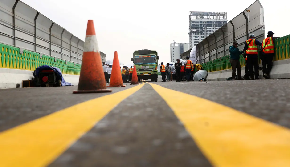 Petugas melakukan uji kelayakan Koridor 13 Transjakarta Tendean - Ciledug , Jakarta, Kamis (20/7). Pengujian dilakukan untuk mengetahui ketahanan konstruksi jalan layang Koridor 13 yang direncanakan segera beroperasi. (Liputan6.com/Angga Yuniar)