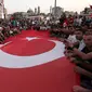 Bendera nasional Turki berukuran besar dibentangkan pendukung Presiden Turki, Tayyip Erdogan di Taksim Square, pusat kota Istanbul, Sabtu (16/7). Ratusan warga turun ke jalan untuk merayakan kegagalan kudeta militer di Turki. (REUTERS/Huseyin Aldemir)