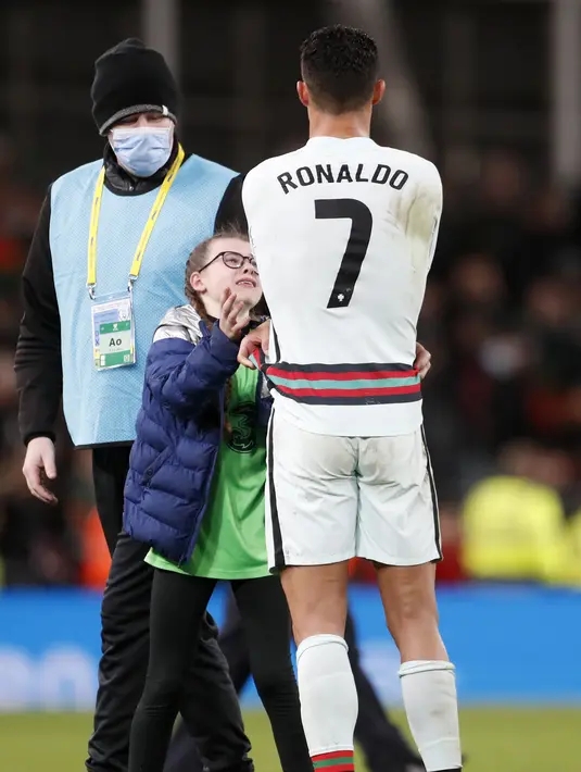Penyerang Portugal Cristiano Ronaldo memberikan jerseynya untuk fans cilik Irlandia pada akhir laga Grup A Kualifikasi Piala Dunia 2022 Zona Eropa di Stadion Aviva, Jumat (12/11/2021) dinihari WIB. Ronaldo yang tengah berjalan menuju ruang ganti tiba-tiba didatangi fans cilik. (AP/Peter Morrison)