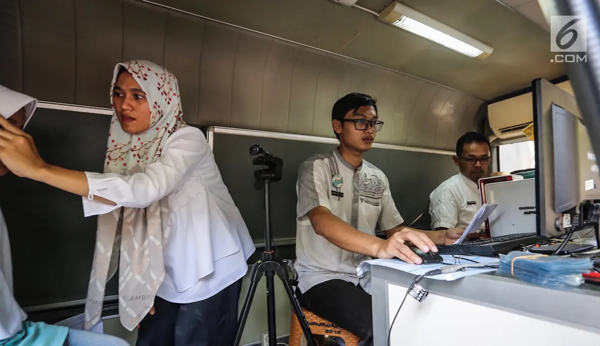 Petugas Disdukcapil menginput data pembuatan Kartu Identitas Anak (KIA) di Pondok Aren, Tangerang Selatan, Jumat (16/11). KIA tidak dilampiri foto untuk anak berusia 1 hingga 5 tahun, sementara 6 hingga 16 tahun terdapat foto. (Liputan6.com/Fery Pradolo)