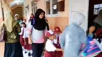 Emak-emak ikut mengantre di depan kelas, untuk peroleh bangku di hari pertama sekolah. (Foto: Liputan6.com/Muhamad Ridlo)