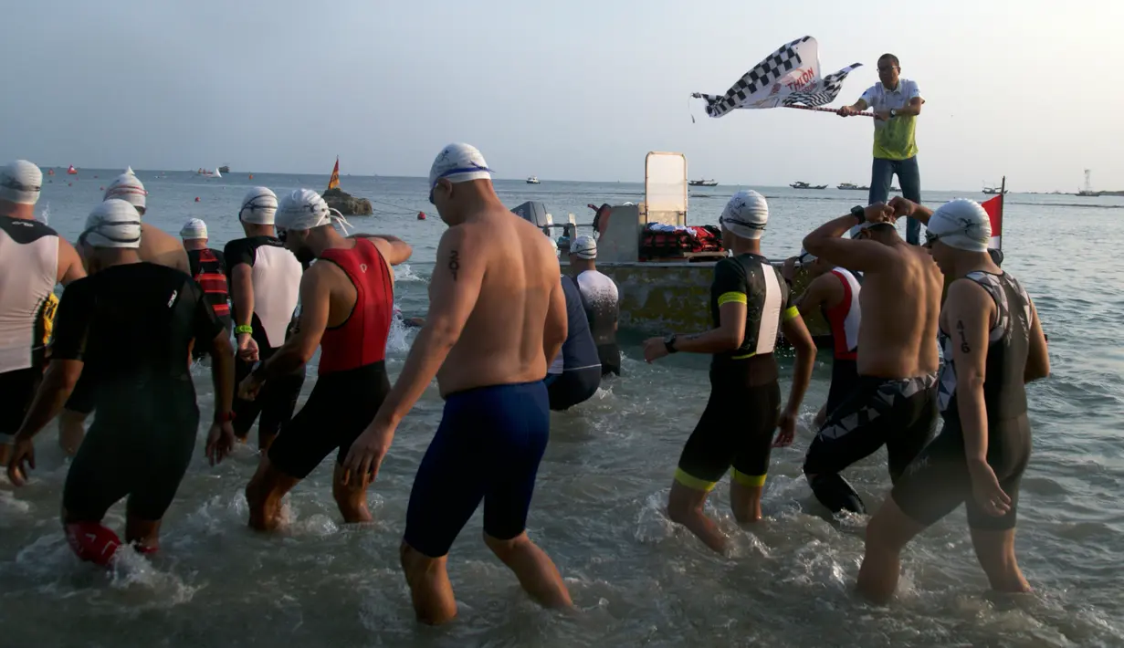 Peserta menuju bibir pantai sebelum berenang ketika Rhino Cross Triathlon 2018 di Kawasan Tanjung Lesung, Pandeglang, Banten, Minggu (30/9). Rhino Cross Triathlon digelar untuk meningkatkan potensi wisata Tanjung Lesung. (Liputan6.com/HO/Nick Hanoatubun)