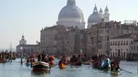 Suasana kemeriahan Karnaval Venesia saat perahu-perahu berlayar dalam parade dayung tradisional. (AP Photo/Luca Bruno)