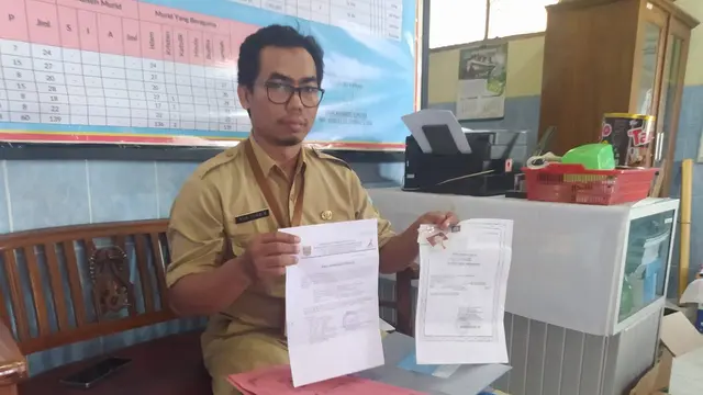 Nur Khabib selaku Kepala Sekolah SDN Ploso 4 Kudus menunjukkan berkas surat pendaftaran kepindahan atas nama Ajib.(Liputan6.com/Arief Pramono)