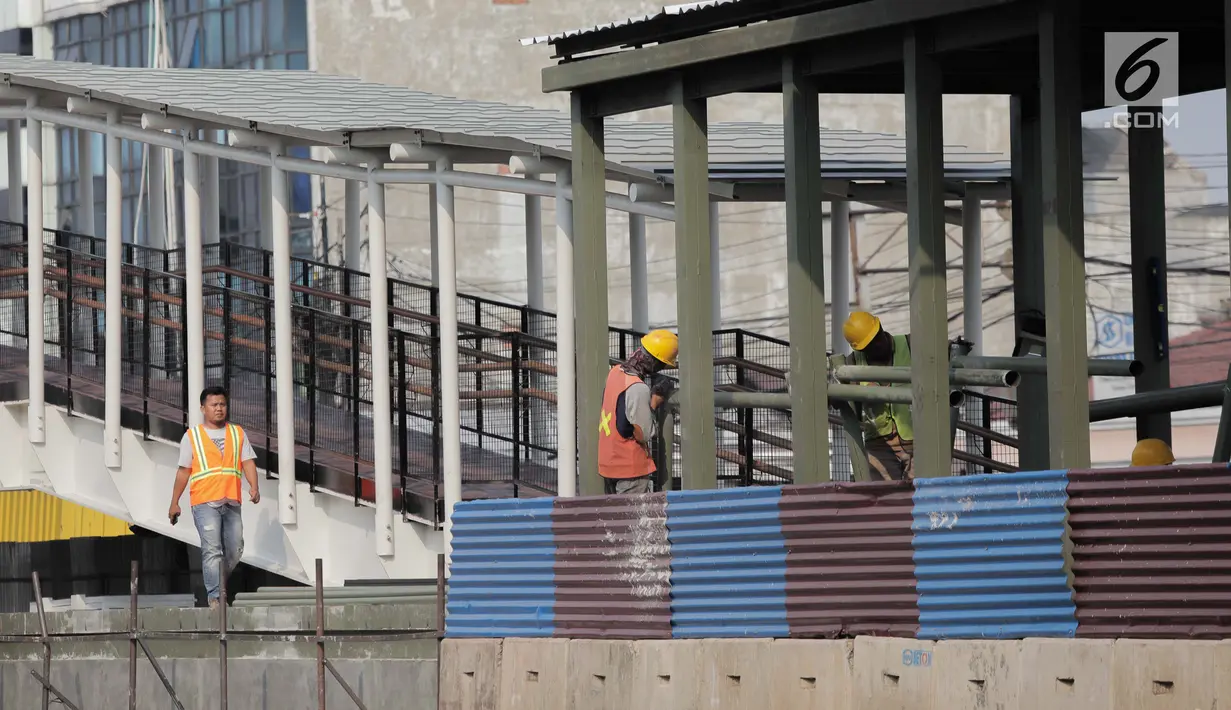 Pekerja menyelesaikan pembangun jembatan Skybridge di Ramangun, Jakarta, Kamis (4/7/2019). Pembangunan Skybridge sudah 98 persen rampung, yang nantinya akan menghubungkan Stasiun Kereta LRT Velodrome dengan halte busway Pemuda Rawamangun akan rampung akhir bulan ini. (Liputan6.com/Faizal Fanani)