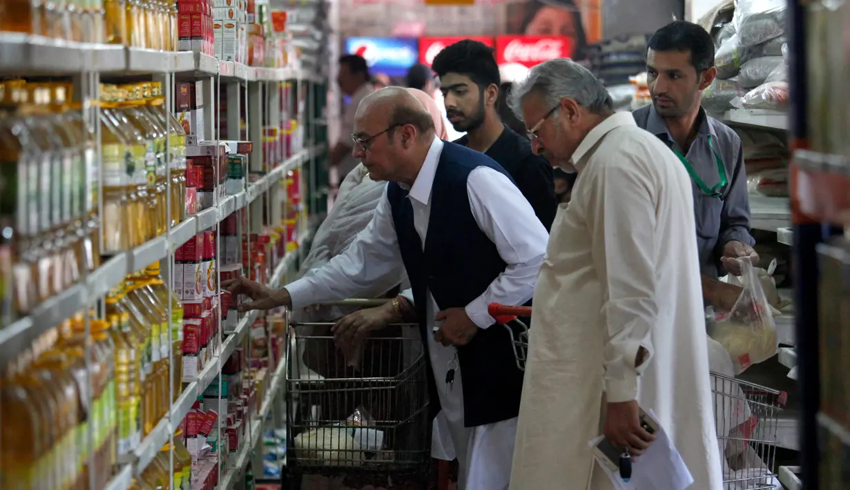 Pengunjung memilih kebutuhan pokok ketika berbelanja di supermarket yang dikelola pemerintah Pakistan di Islamabad, Rabu (16/5). Warga berbelanja memenuhi kebutuhan menyambut Puasa Ramadan yang dimulai pada Kamis (17/5). (AP/Anjum Naveed)
