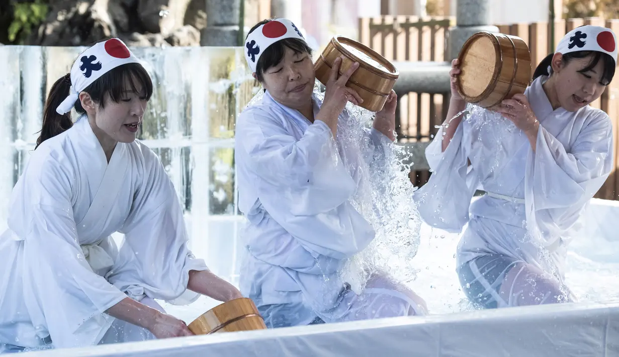 Para wanita penganut Shinto menuangkan air dingin ke tubuh mereka saat melangsungkan ritual ketahanan di Kuil Kanda Myojin, Tokyo, Jepang, Sabtu (26/1). Ritual ini untuk mensucikan jiwa dan raga. (Martin Bureau/AFP)