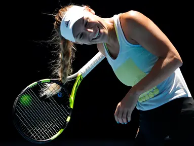 Reaksi petenis Denmark, Caroline Wozniacki ketika rambutnya tersangkut di raket pada sesi latihan menjelang Grand Slam Australia Terbuka di Melbourne, Minggu (14/1). Grand slam tersebut bakal berlangsung 15-28 Januari 2018. (AP/Vincent Thian)