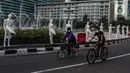 Pesepeda melintasi puluhan boneka maneken yang dipajang di Bundaran HI, Jakarta, Minggu (15/11/2020). Boneka maneken itu sebagai bentuk "Mengenang Korban Kecelakaan Lalu Lintas 2020" dan mengingatkan pengguna jalan agar selalu patuhi peraturan lalu lintas demi keselamatan. (Liputan6.com/Johan Tallo)