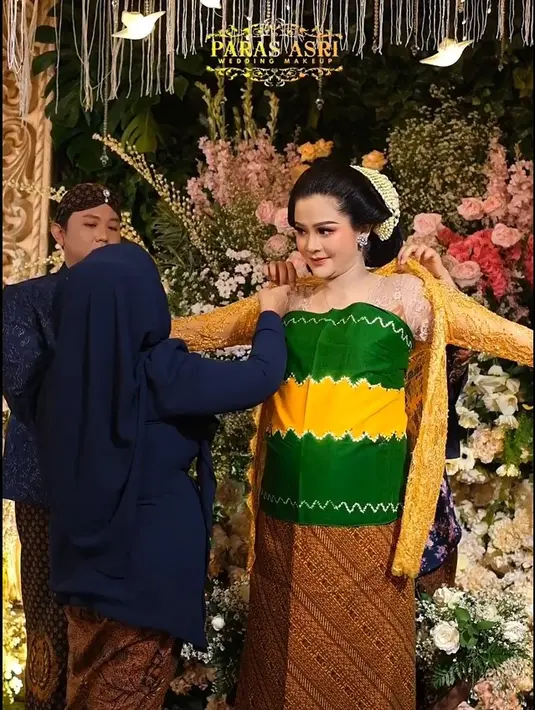 Salah satu tradisi Jawa dalam acara mitoni adalah momen ganti kebaya untuk calon ibu. Tidak sembarang batik, karena setiap motifnya memiliki makna tersendiri. Potret Bella saat menggunakan kebaya pertama warna kuning. [Instagram/asrileksono_parasasriofficial]