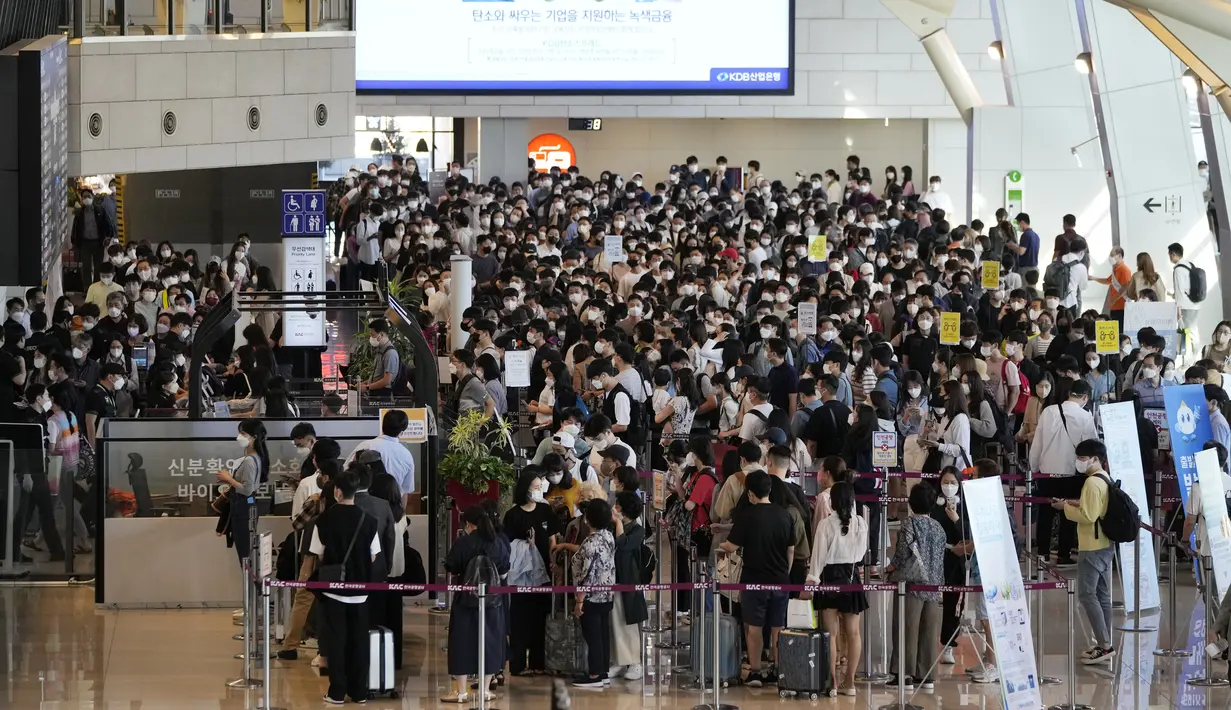 Penumpang yang mengenakan masker sebagai tindakan pencegahan terhadap virus corona berbaris untuk naik pesawat menjelang liburan Chuseok, Hari Thanksgiving versi Korea di terminal penerbangan domestik bandara Gimpo di Seoul, Korea Selatan (18/9/2021). (AP Photo/Ahn Young-joon)