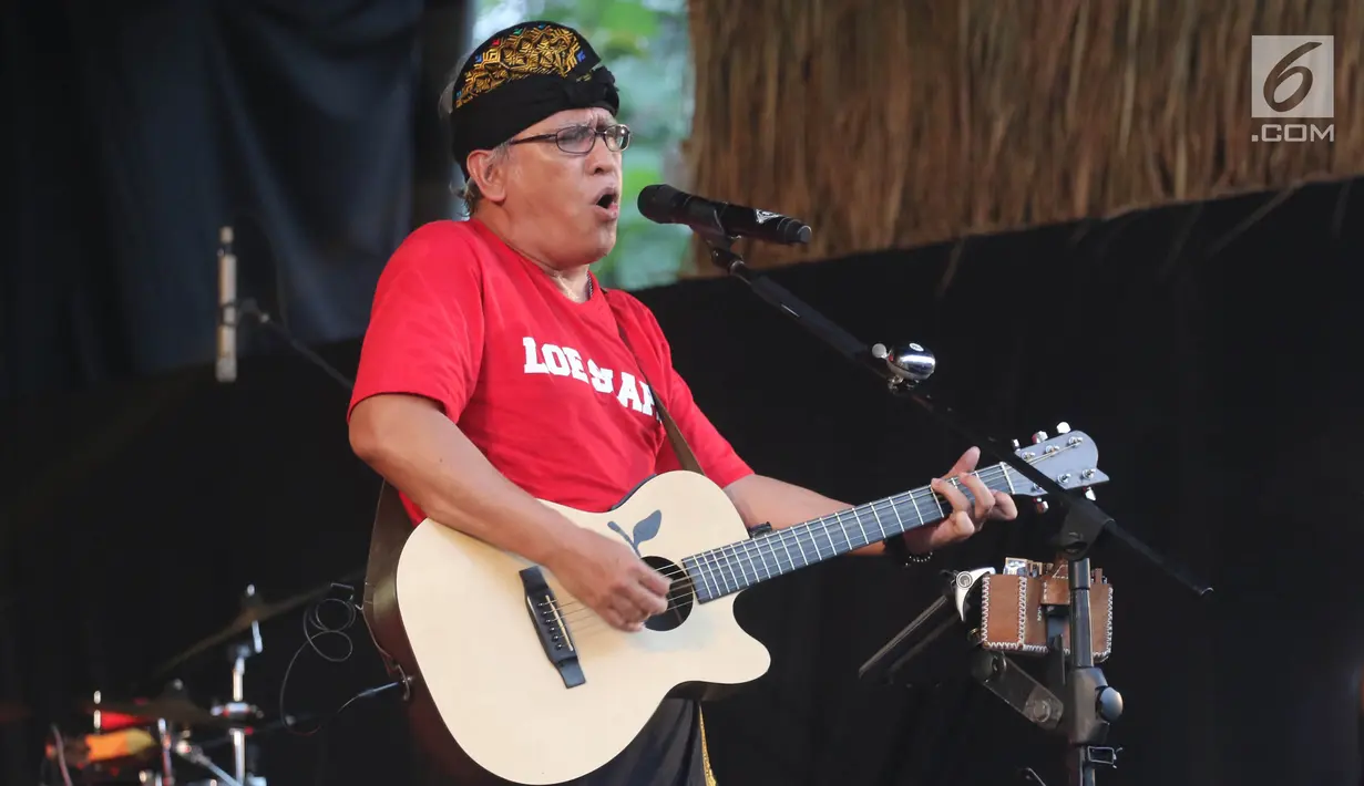 Penyanyi Iwan Fals membawakan lagu sambil bermain gitar dalam Seri Konser Situs Budaya di Panggung Kita, Depok, Sabtu (3/3). Dalam konser tersebut, Iwan Fals membawakan lagu-lagu daerah seperti Tegining Amaq dan Sarompi Mpida. (Liputan6.com/Arya Manggala)