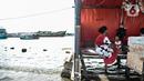 Aktivitas warga saat banjir rob merendam kawasan Pelabuhan Kali Adem, Muara Angke, Jakarta, Kamis (22/10/2020). Banjir akibat air pasang dengan ketinggian mencapai 30 cm tersebut telah merendam kawasan Pelabuhan Kali Adem dan sudah berlangsung selama lima hari. (merdeka.com/Iqbal S. Nugroho)