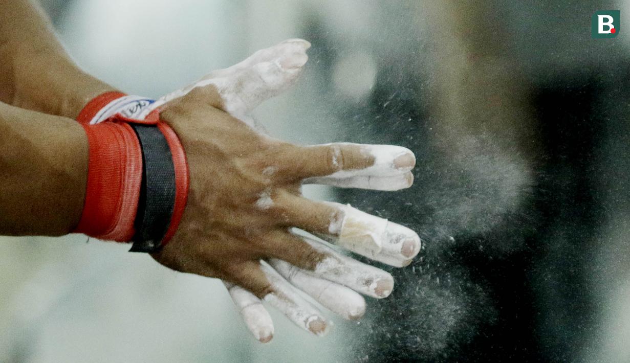 Atlet angkat besi, Deni, memakai Bubuk Magnesium karbonat saat latihan di Pelatnas angkat besi, Jakarta, Rabu (21/3/2018). Latihan tersebut untuk persiapan Asian Games 2018. (Bola.com/M Iqbal Ichsan)