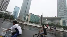 Dua warga bersepeda di kawasan Car Free Day, Jakarta, Minggu (28/2/2016). Hujan yang mengguyur Ibukota sejak semalam hingga pagi membuat kawasan CFD sepi pengunjung. (Liputan6.com/Immanuel Antonius)