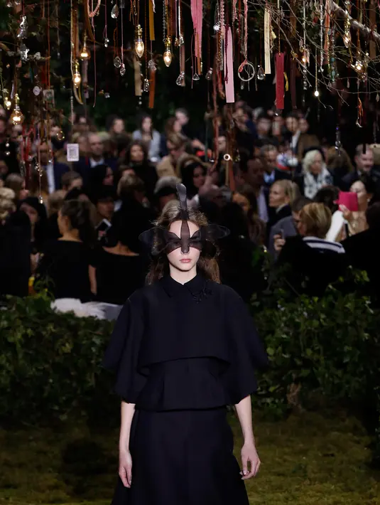 Seorang model membawakan rancangan Christian Dior untuk koleksi spring/summer 2017 di Musee Rodin, Paris, Senin (23/1). Di awal pertunjukkan, variasi busana serba hitam dengan potongan maskulin mendominasi sekuen pertama. (FRANCOIS Guillot/AFP)