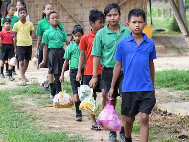 Gambar pada 20 Mei 2019, siswa India mengantre membawa tas plastik berisi sampah plastik di sekolah Forum Akshar di desa Pamohi, Guwahati. Sekolah ini mengambil pendekatan baru untuk mengatasi momok sampah plastik dengan menjadikannya sebagai syarat pengganti biaya sekolah. (Biju BORO/AFP)
