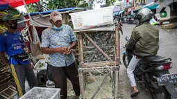 Pedagang burung pipit menjajakan dagangannya di kawasan Pasar Petak Sembilan, Glodok, Jakarta, Minggu (31/1/2021). Pedagang pipit mengaku mengalami penurunan omzet saat pandemi karena banyak vihara yang tak menyelenggarakan ibadah untuk mengurangi penyebaran COVID-19. (Liputan6.com/Faizal Fanani)