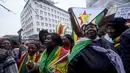 Sejumlah demonstran berkumpul menggelar aksi protes di luar Kedutaan Besar Zimbabwe di London, Sabtu (18/11). Mereka berkumpul mendukung runtuhnya rezim Presiden Robert Mugabe. (NIKLAS HALLE'N/AFP)