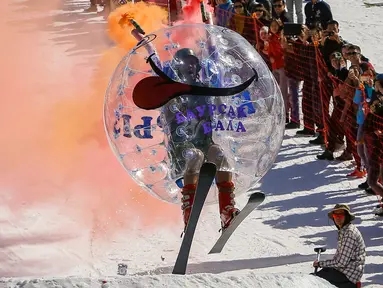 Peserta mengenakan kostum bola transparan meluncur kencang saat mengikuti kontes Jump Red Bull dan Freeze di ski resort Chimbulak, Kazakhstan (22/3). Dalam kontes ini para peserta mengundang tawa penonton yang menyaksikan. (REUTERS/Shamil Zhumatov)