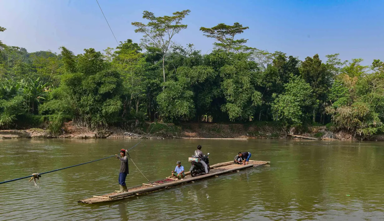 Warga bersama sepeda motornya menyeberangi Sungai Cisadane menggunakan rakit bambu di kawasan Ciseeng, Kabupaten Bogor, Jawa Barat, Kamis (11/6/2026). (merdeka.com/Arie Basuki)