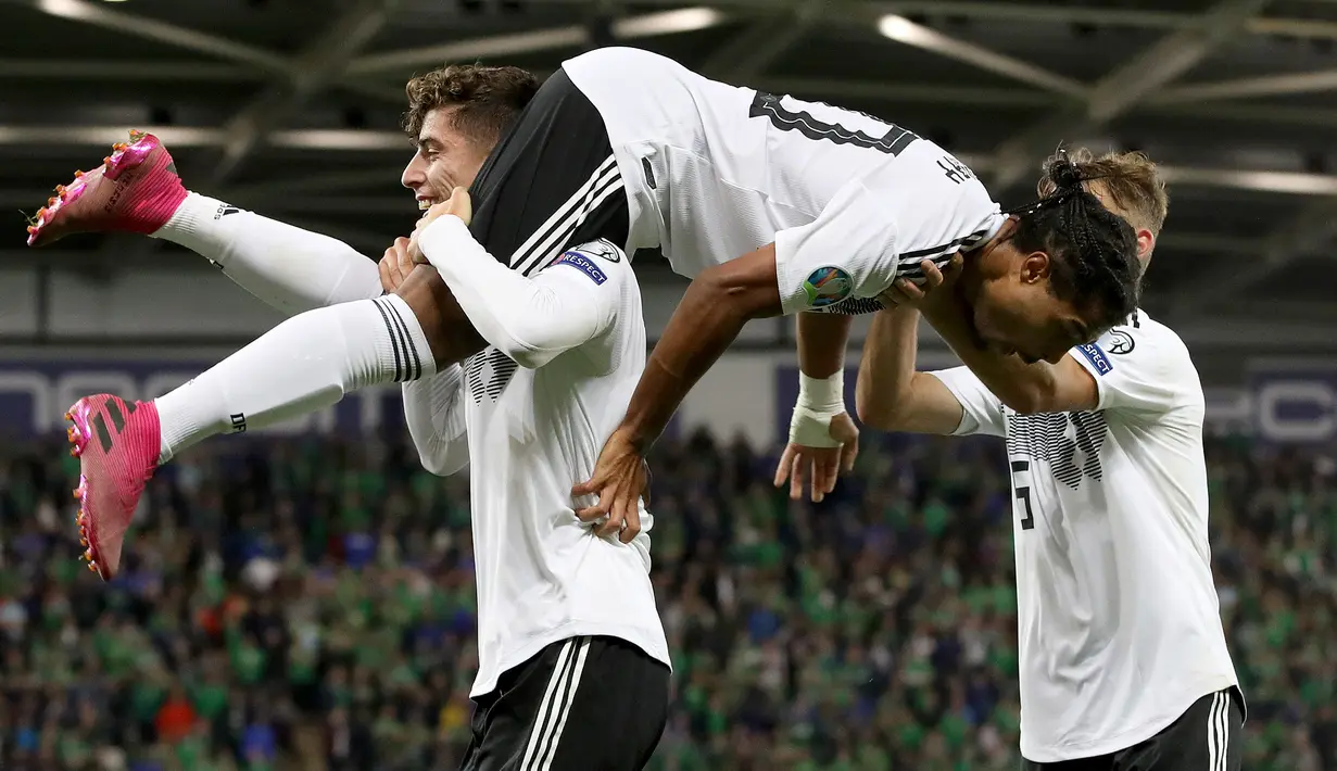 Pemain tengah Jerman, Serge Gnabry (tengah) merayakan golnya ke gawang Irlandia Utara saat bertanding dalam kualifikasi Euro 2020 di Windsor Park, Belfast, Senin (9/9/2019). Jerman berhasil merebut puncak klasemen grup C kualifikasi Euro 2020 usai mengalahkan Irlandia Utara 2-0. (Paul Faith/AFP)