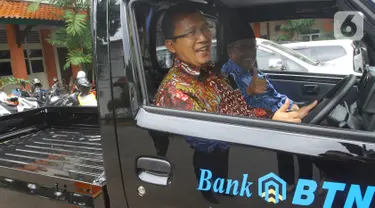 Direktur Utama Bank BTN Haru Koesmahargyo menaiki mobil sarana kebersihan usai serah terima bantuan tanggung jawab sosial dan lingkungan (TJSL) berupa kendaraan sarana kebersihan di Kampus UIN Sultan Maulana Hasanuddin, Serang, Banten, Kamis (17/3/2022). (Liputan6.com/HO/BTN)