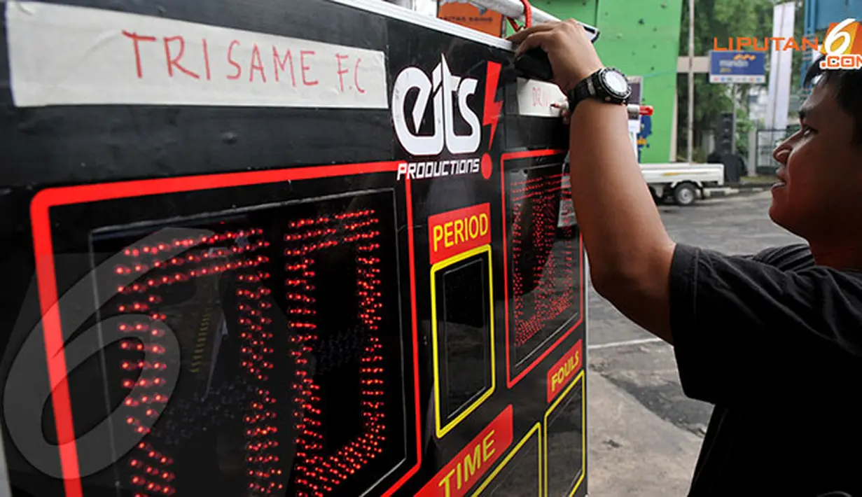 Seorang panitia mempersiapkan papan skor untuk pertandingan Futsal Challenge Road to BPL di Universitas Sahid, Jakarta. (Liputan6.com/Abdul Aziz Prastowo)