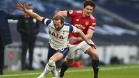Striker Tottenham Hotspur Harry Kane diadang bek Manchester United atau MU dalam laga Liga Inggris di Tottenham Hotspur Stadium, Minggu (11/4/2021). (Clive Rose / Pool via AP)